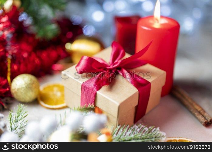 christmas gift boxes with a red bow with candles and decorations on the tree and pine for the new year
