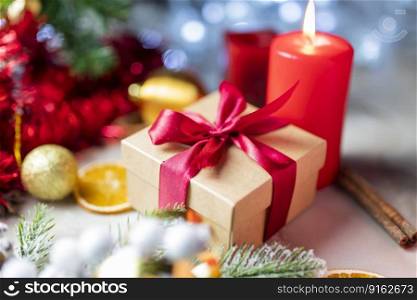 christmas gift boxes with a red bow with candles and decorations on the tree and pine for the new year