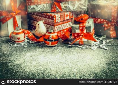 Christmas gift boxes with red ribbons and decoration on rustic background, side view.