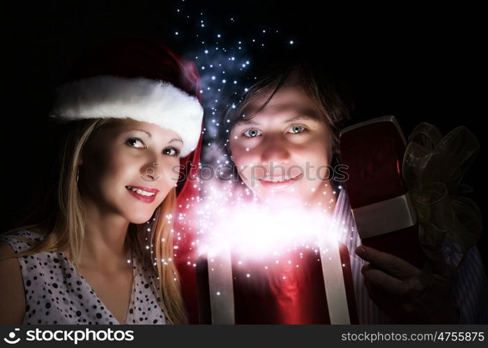 Christmas gift. Happy family of man and woman opening Christmas gifts