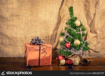 Christmas gift on a wooden table with shiny baubles