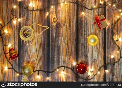 Christmas gifts and lights on wooden floor