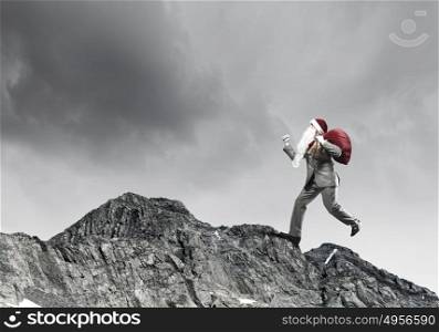Christmas gifts delivery!. Businessman in Santa hat running with bag on back