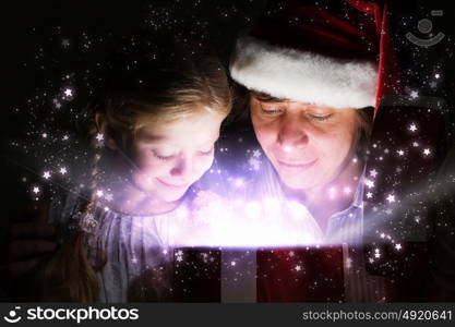 Christmas gifts. Father and his happy daughter opening Christmas gift