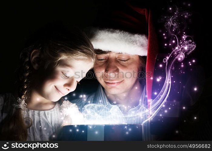 Christmas gifts. Father and his happy daughter opening Christmas gift
