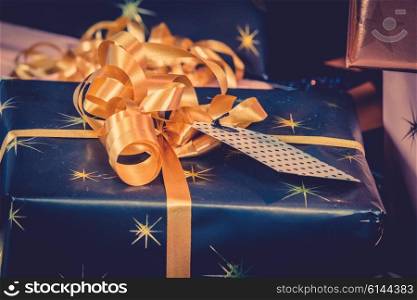 Christmas gifts in dark blue color with golden ribbon