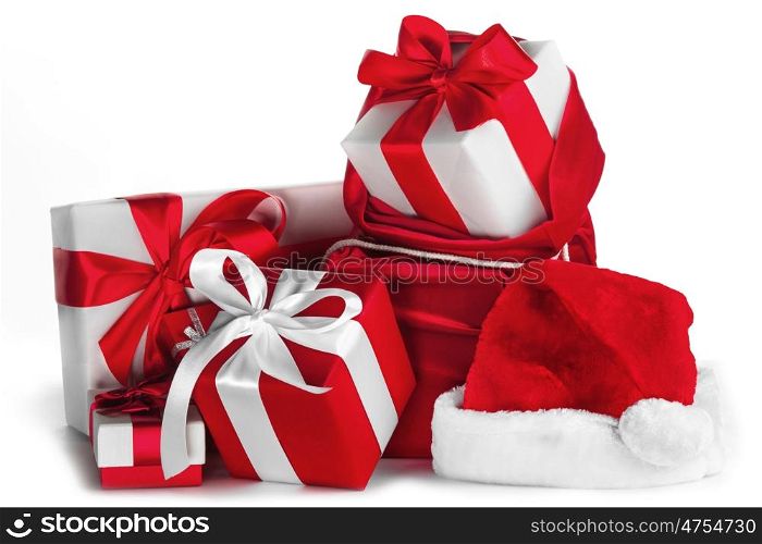 Christmas gifts on white. Red Santa bag with christmas gifts with bows and Santa hat isolated on white background