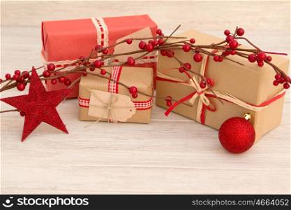 Christmas gifts wrapped with brown paper and decorated with white ribbons and red
