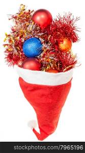 christmas gifts - xmas balls and decorations spillover from red santa hat on white background