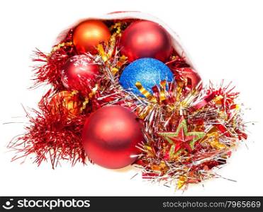 christmas gifts - xmas balls, star and decorations fall out from red santa hat on white background