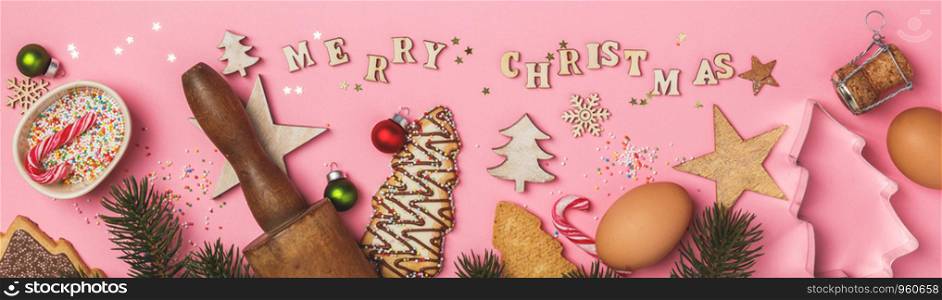Christmas gingerbread cookies in the shape of a Christmas tree, baking ingredients and Merry Christmas written with wooden letters on pink background