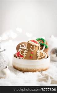 Christmas gingerbread cookies with Christmas decorations on white snow background. Traditional Christmas baking. Christmas gingerbread cookies