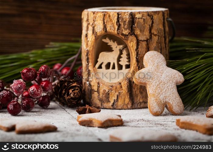 Christmas gingerbread with fir branches, cranberries and cinnamon on wooden background