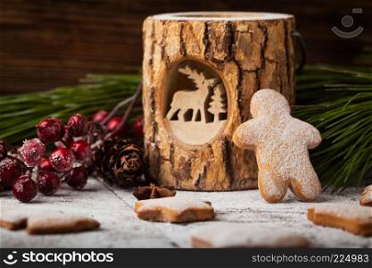 Christmas gingerbread with fir branches, cranberries and cinnamon on wooden background