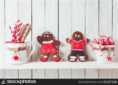 Christmas gingermen family on a kitchen wooden shelf. Christmas gingermen family