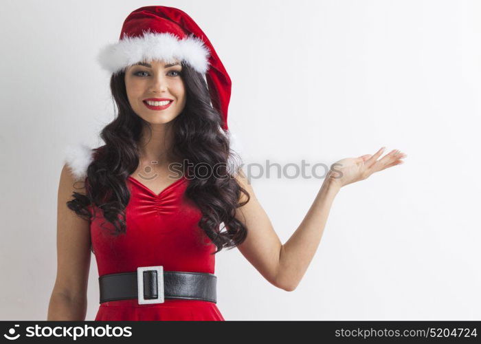 Christmas girl holding something. Young brunette christmas girl holding something on white background, copy space for text