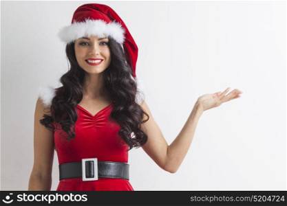 Christmas girl holding something. Young brunette christmas girl holding something on white background, copy space for text