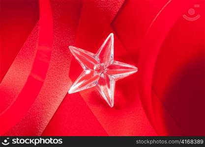 christmas glass star on red ribbon background