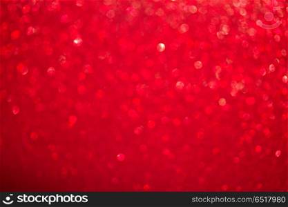Christmas glittering background. Christmas festives glittering defocused red background with bokeh lights