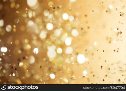 Christmas gold background. Golden holiday glowing abstract glitter defocused background