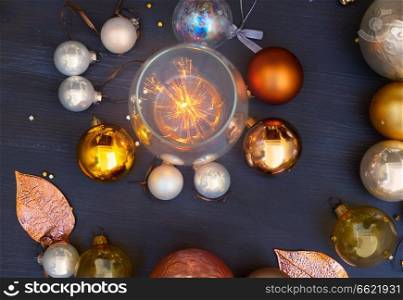 Christmas golden and silver decorations on dark wooden background with shining light. Christmas golden decorations