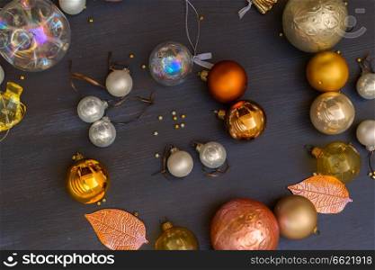 Christmas golden and silver decorations spiral on dark wooden background, frame with copy space. Christmas golden decorations