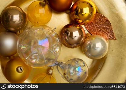 Christmas golden balls decorations close up on golden plate. Chhristmas red, golden and white decoration