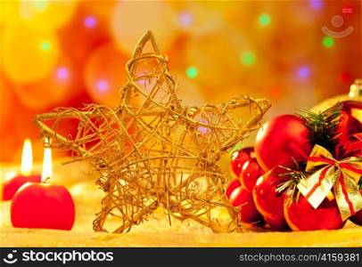 Christmas golden branch star with candles and baubles in blurred lights