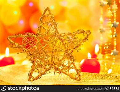 Christmas golden branch star with candles in blurred lights