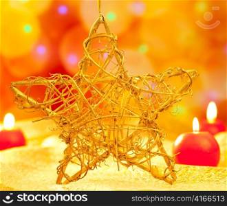 Christmas golden branch star with candles in blurred lights