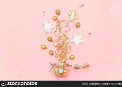 Christmas golden decoration toy, garland, baubles fly out of glass jar on pink background with copy space. Merry christmas or Happy new year concept. Flat lay Top view Template for design, postcard.. Christmas golden decoration toy, garland, baubles fly out of glass jar on pink background with copy space. Merry christmas or Happy new year concept. Flat lay Top view Template for design, postcard