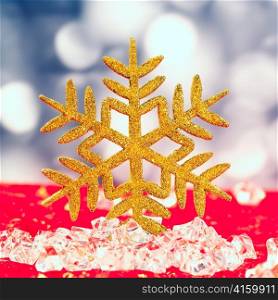 Christmas golden snowflake on ice cubes with blue lights bokeh background