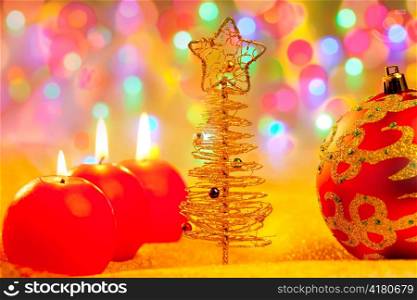 Christmas golden tree and red baubles in blur lights background