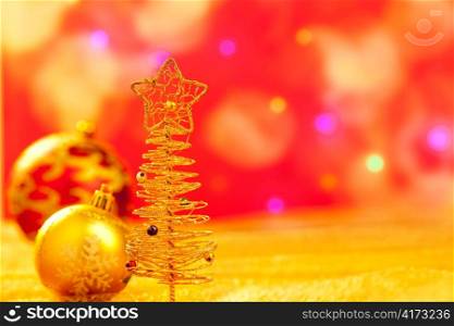 Christmas golden tree with babubles in blur lights background