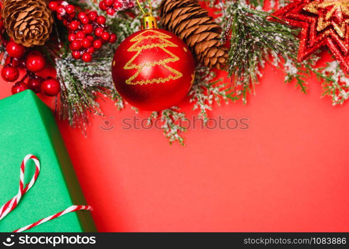 Christmas green gift box and decorations, fir tree branches on red background. Merry Christmas concept. With Copy space for text