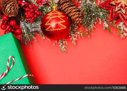 Christmas green gift box and decorations, fir tree branches on red background. Merry Christmas concept. With Copy space for text