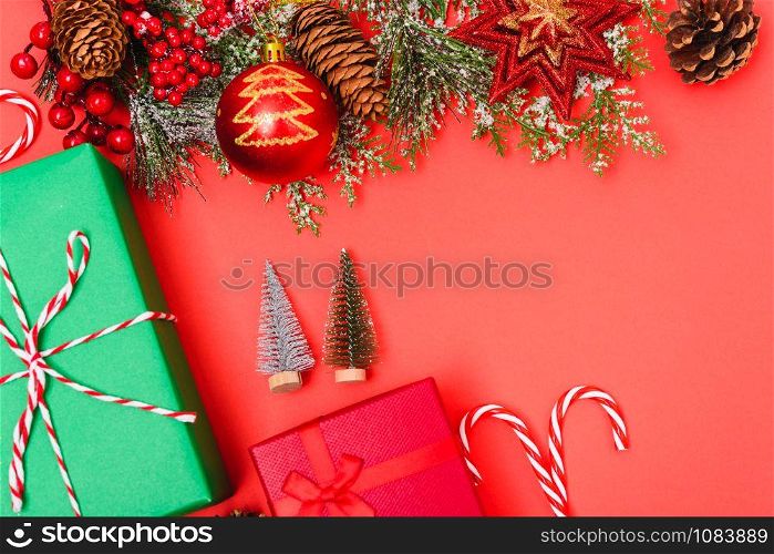 Christmas green gift box and decorations, fir tree branches on red background. Merry Christmas concept. With Copy space for text