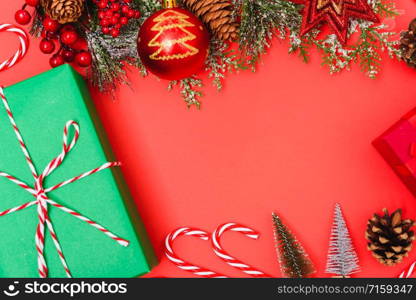 Christmas green gift box and decorations, fir tree branches on red background. Merry Christmas concept. With Copy space for text