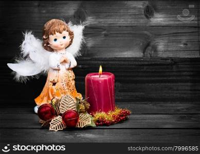 Christmas greeting card with candle and angels on wooden background black and white.