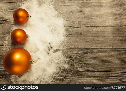 Christmas greeting card with Christmas balls and snow on a wooden background.. Christmas greeting card with Christmas balls and snow on a wooden background