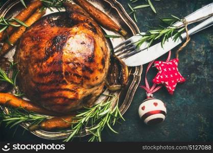 Christmas ham on plate with festive decoration and cutlery, top view
