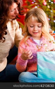 Christmas - happy family (mother with daughter) with gifts on Xmas Eve