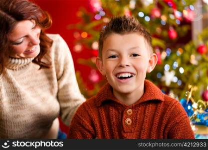 Christmas - happy family (mother with son) on Xmas Eve in front of Christmas tree