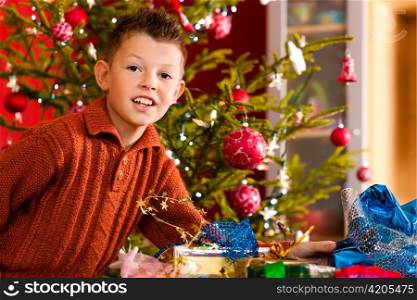 Christmas - happy little boy with Xmas present on Christmas Eve