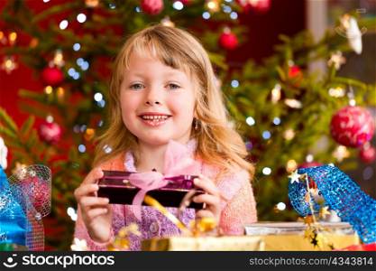 Christmas - happy little girl with Xmas present on Christmas Eve