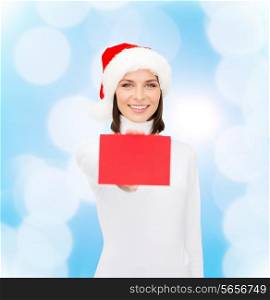 christmas, holdays, people, advertisement and sale concept - happy woman in santa helper hat with blank red card over blue lights background