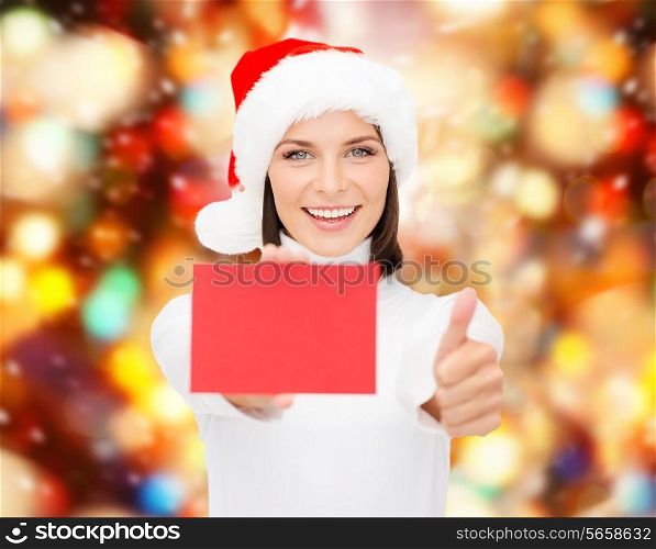 christmas, holdays, people, advertisement and sale concept - happy woman in santa helper hat with blank red card showing thumbs up gesture over lights background