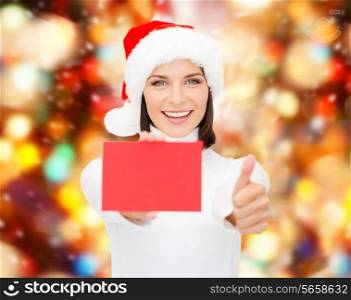 christmas, holdays, people, advertisement and sale concept - happy woman in santa helper hat with blank red card showing thumbs up gesture over lights background