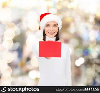 christmas, holdays, people, advertisement and sale concept - happy woman in santa helper hat with blank red card over lights background