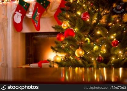 Christmas holiday background of wooden table against decorated Christmas tree and fireplace